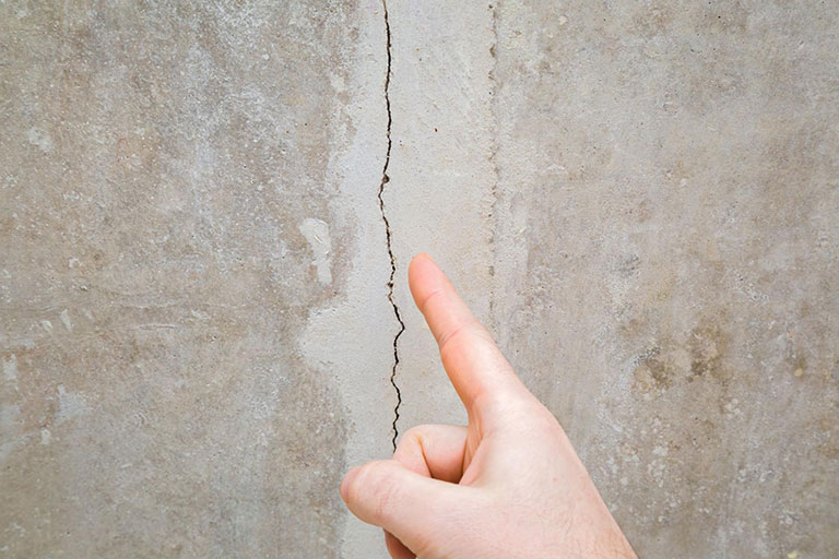 Close-up of a finger pointing to a foundation crack
