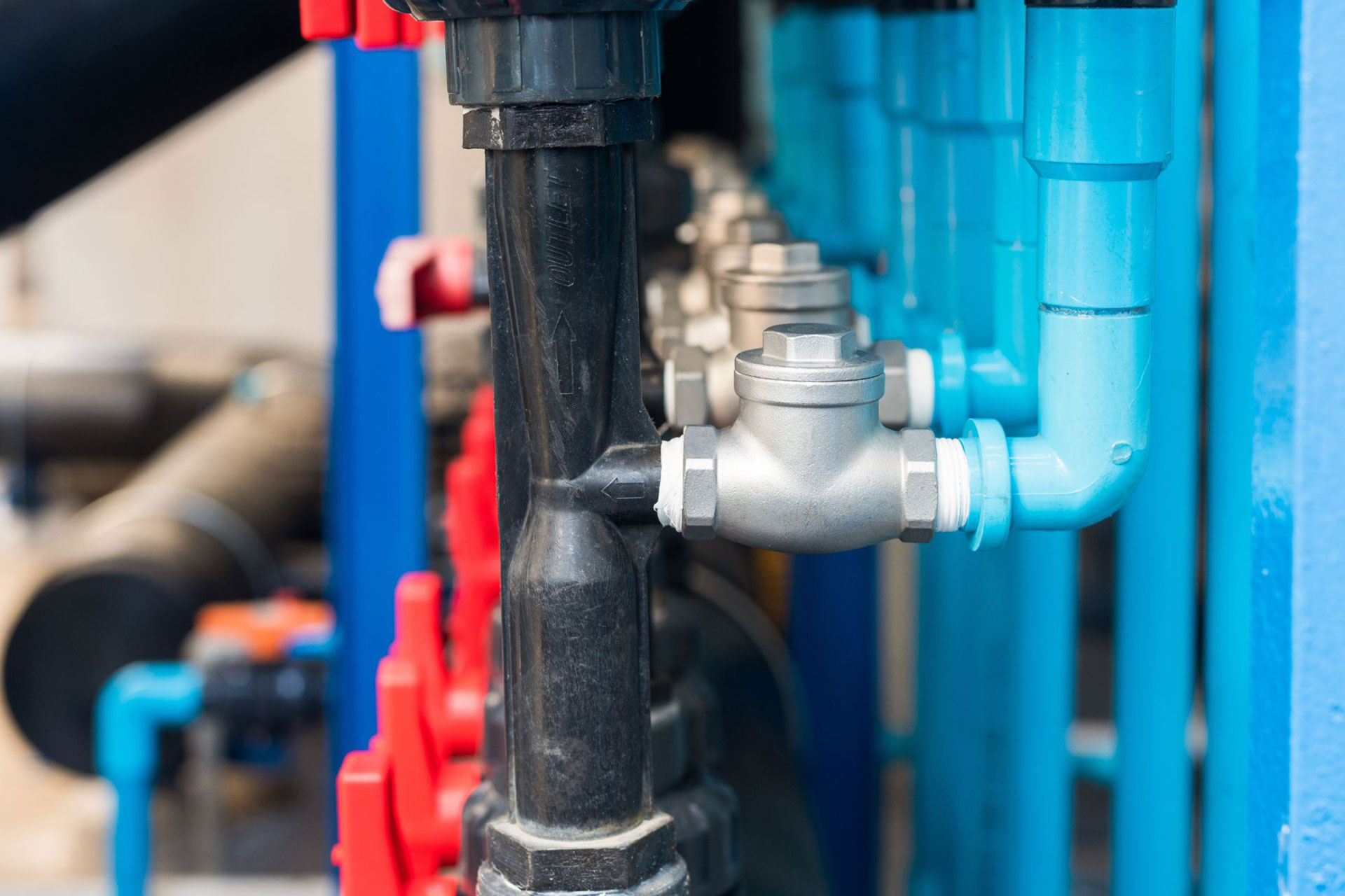 A row of backwater valves connected to a complex plumbing system