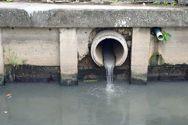 Sewage water flowing out of a concrete pipe